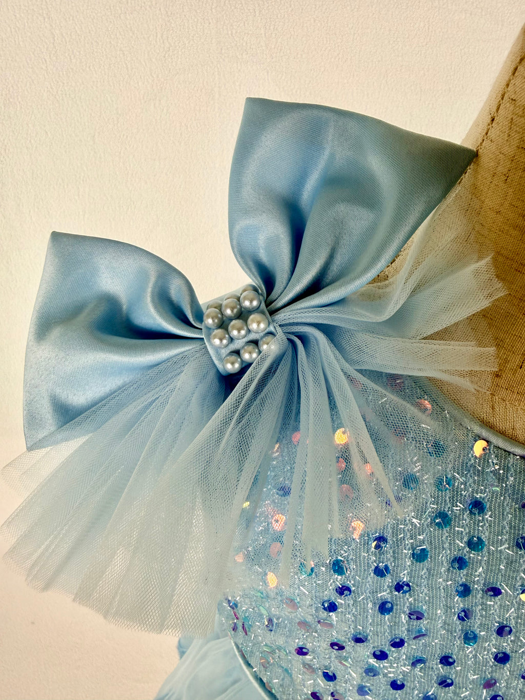 Closeup of light blue tulle sequin one shoulder girls party dress, suitable for  birthdays, flower girls, photo shoots, formal occasions