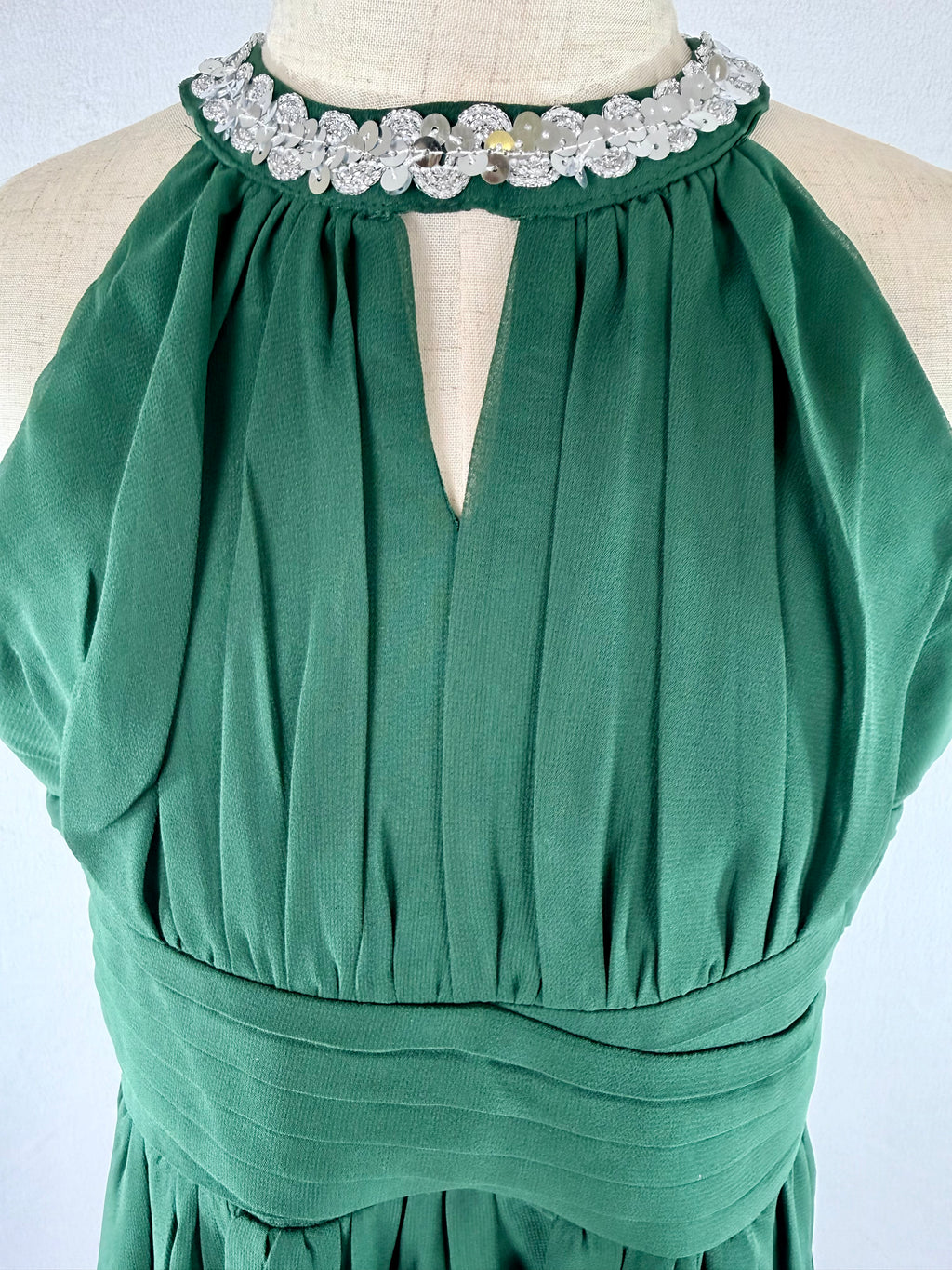Closeup of green halter neck chiffon girls party dress, suitable for birthdays, bridesmaids, and formal occasions