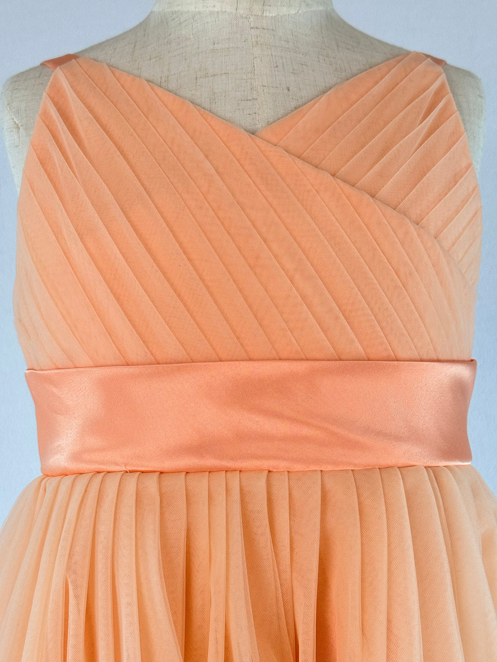 Closeup of peach net tulle girls party dress, suitable for birthdays, flower girls, and formal occasions