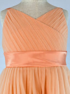 Closeup of peach net tulle girls party dress, suitable for birthdays, flower girls, and formal occasions