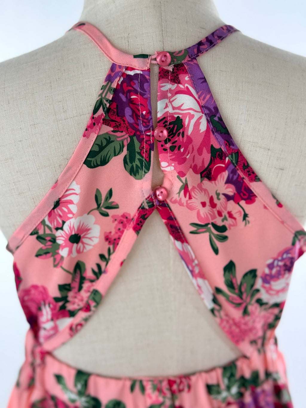 Closeup of back view of pink floral high-low halter neck girls party dress, suitable for birthdays, weddings, parties, photoshoots and graduations