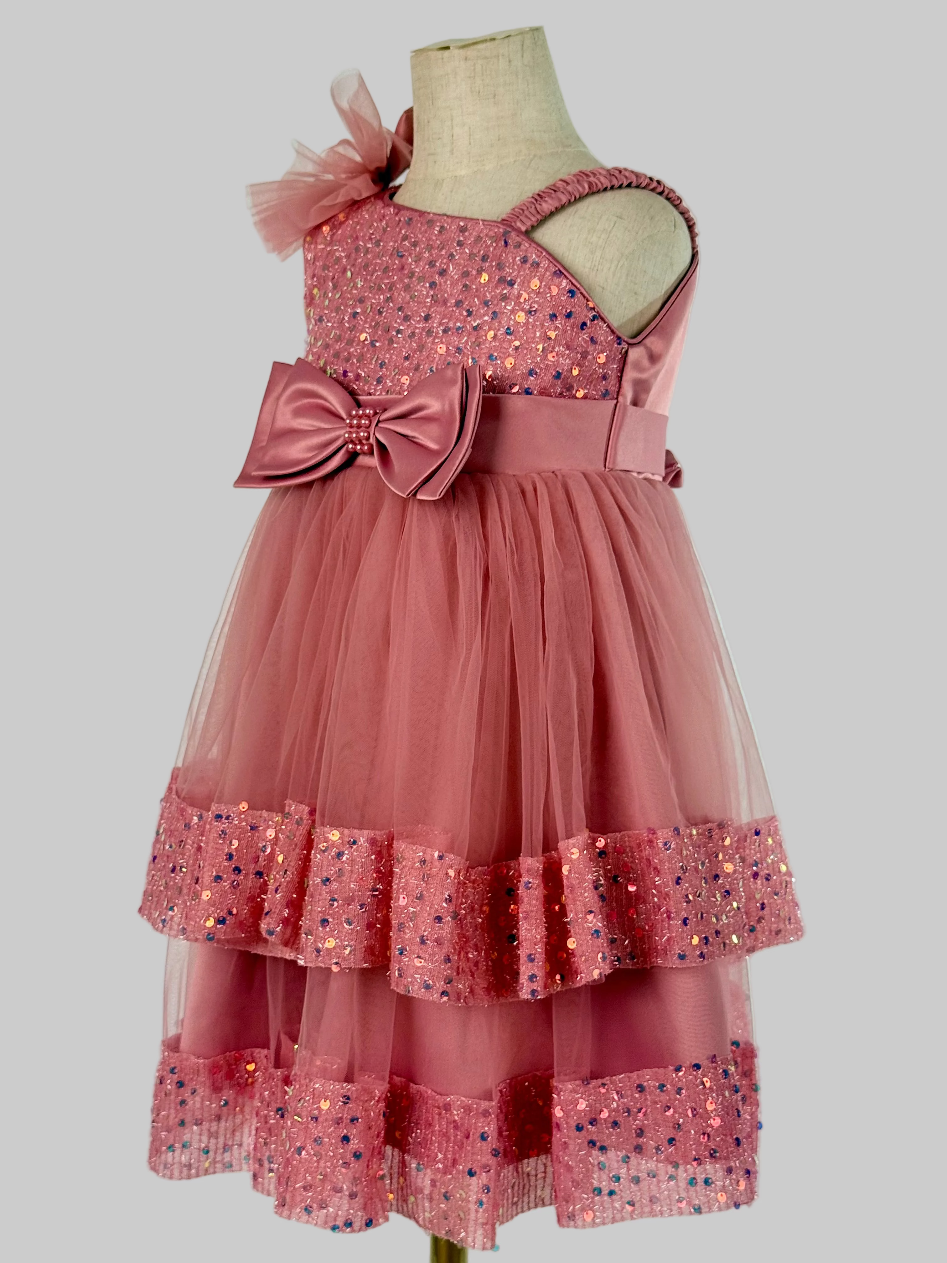 Side view of blush pink tulle sequin one shoulder girls party dress, suitable for  birthdays, flower girls, photo shoots, formal occasions