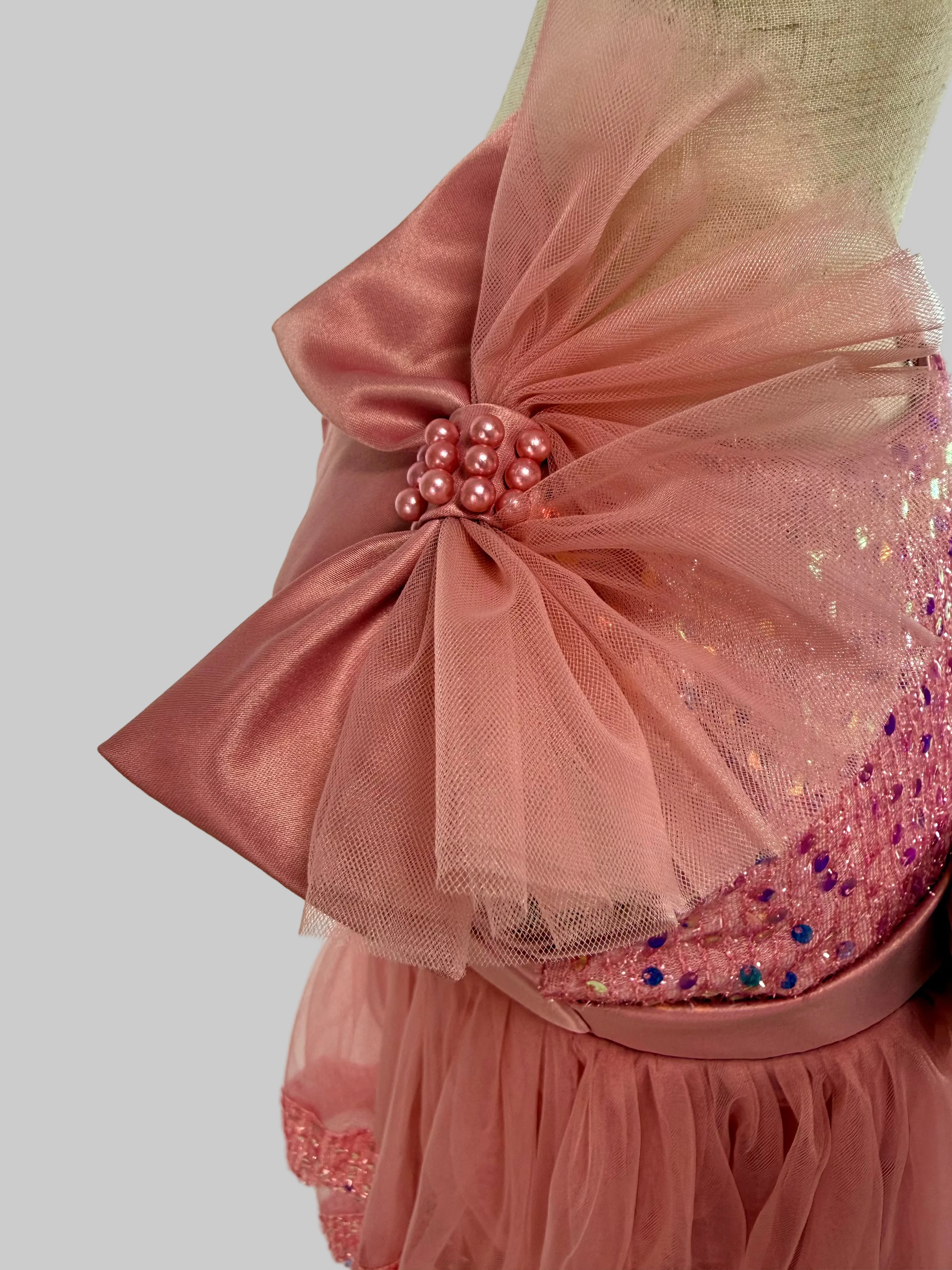 Closeup of blush pink tulle sequin one shoulder girls party dress, suitable for  birthdays, flower girls, photo shoots, formal occasions