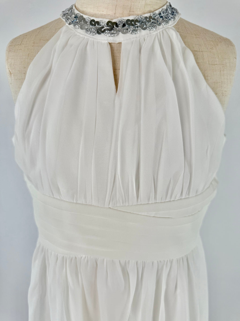 Closeup of white halter neck chiffon girls party dress, suitable for birthdays, bridesmaids, and formal occasions
