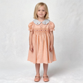 Front view of peach smocked dress. Suitable for birthdays, family gatherings, special occasions, or everyday.