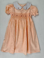 Front view of peach smocked dress. Suitable for birthdays, family gatherings, special occasions, or everyday.