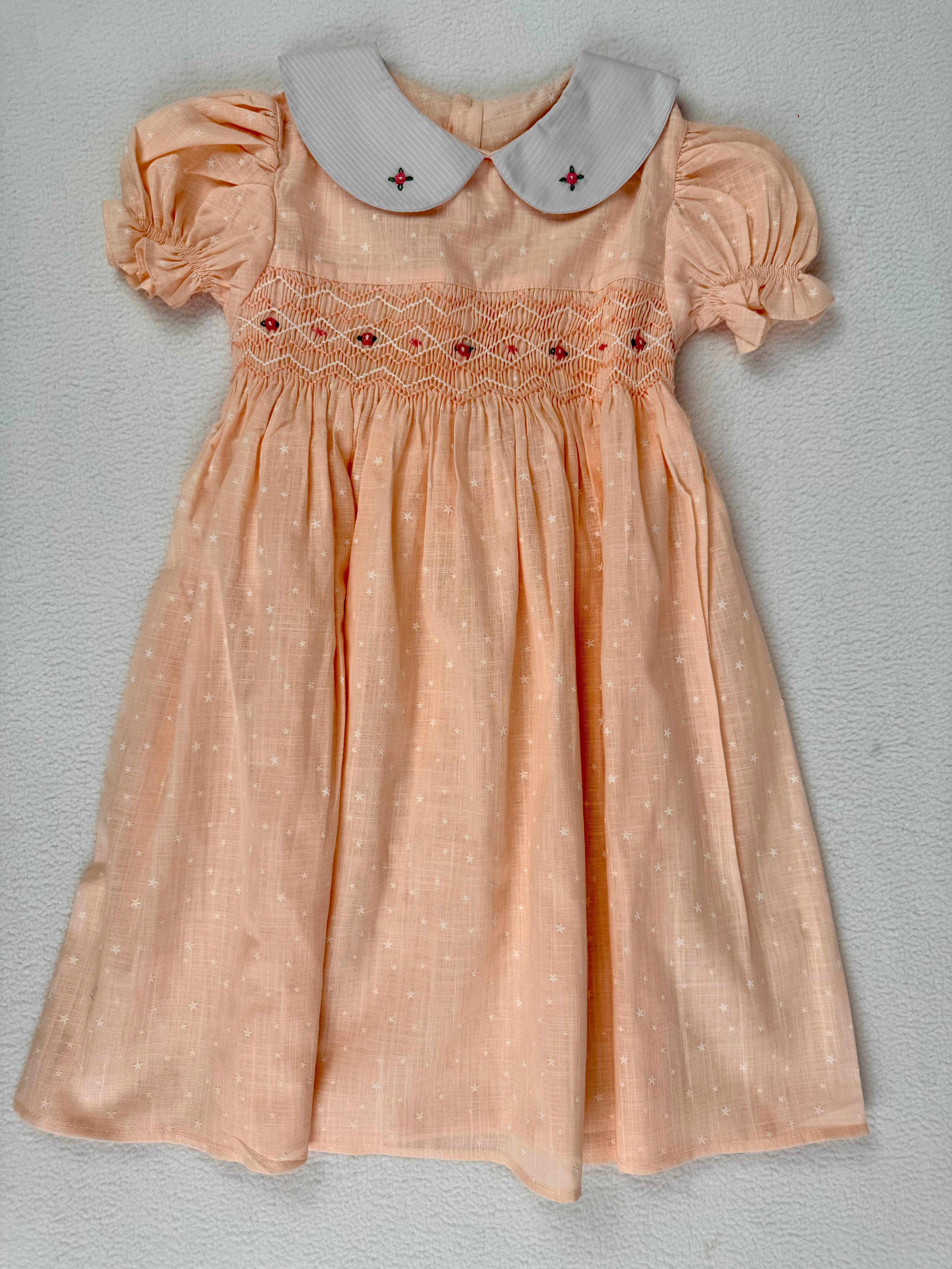 Front view of peach smocked dress. Suitable for birthdays, family gatherings, special occasions, or everyday.