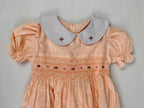 Close up of peach smocked dress. Suitable for birthdays, family gatherings, special occasions, or everyday.