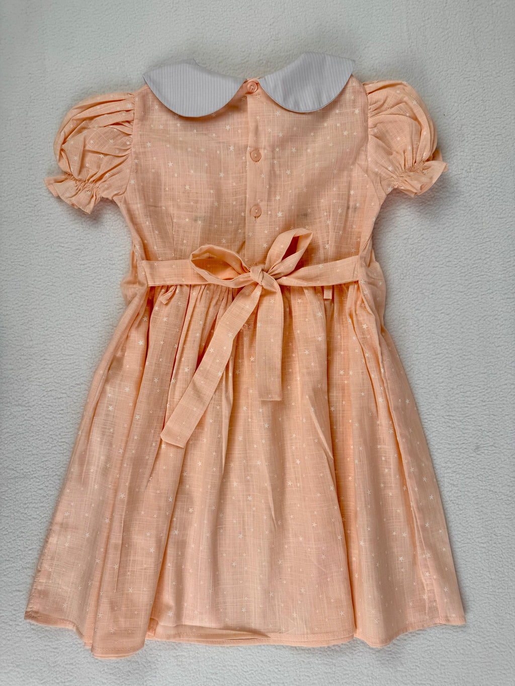 Back view of peach smocked dress. Suitable for birthdays, family gatherings, special occasions, or everyday.